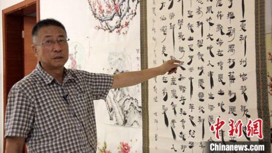 圖為朱群和他的敦煌漢簡(jiǎn)書(shū)體?！「攥?攝