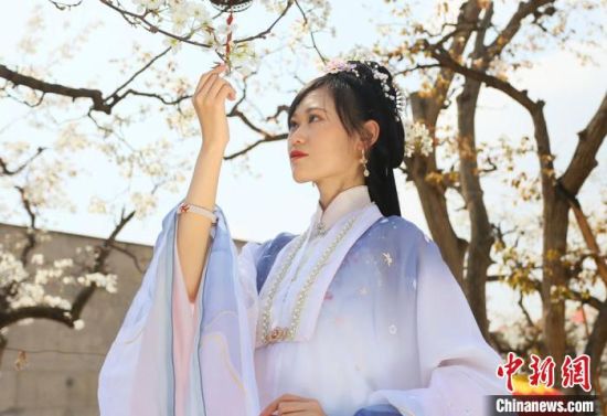 圖為蘭州青年身穿漢服在百年梨園賞景?！「哒?攝