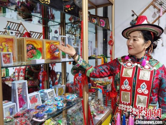 圖為身著民族服飾的隴原巧手展示手工藝品。(資料圖) 徐雪 攝