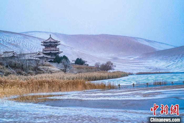 2021年11月28日，雪落鳴沙山月牙泉景區(qū)?！⊥醣筱y 攝