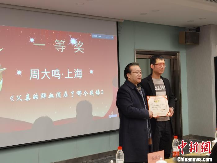 圖為作家、西北師范大學新聞與傳媒學院院長徐兆壽頒發(fā)一等獎證書，代領(lǐng)獎者上臺領(lǐng)獎?！钅?攝