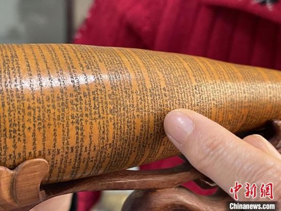 圖為長約二十公分的長條葫蘆雕刻佛教經(jīng)文作品?！堟?攝
