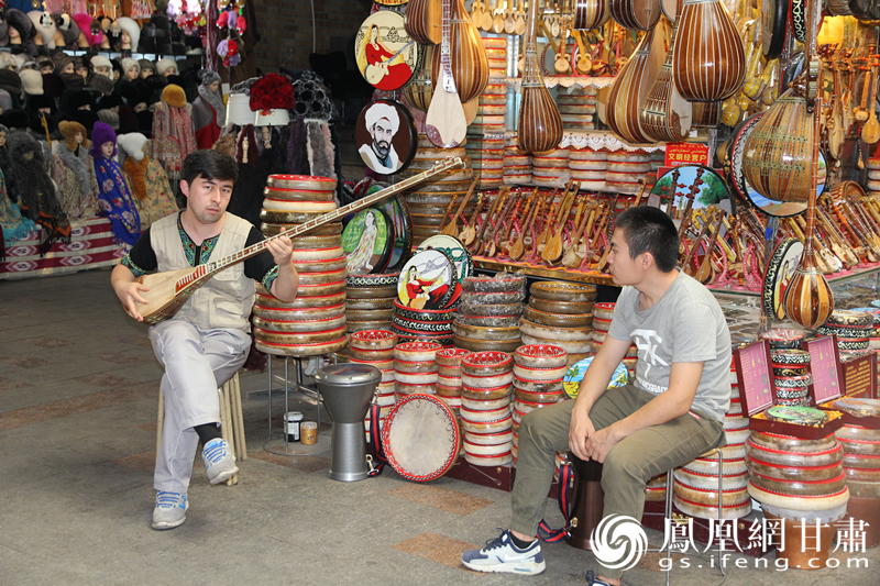 烏魯木齊二道橋巴扎內(nèi)，店主正在向客人展示樂器。楊文遠 攝