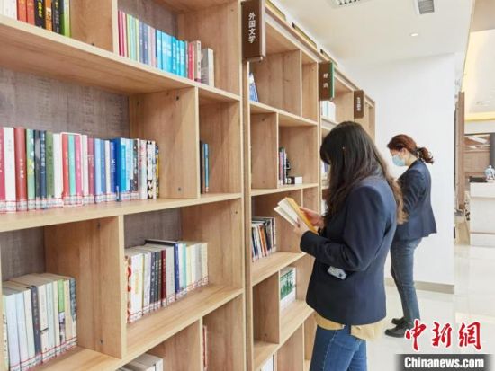 圖為在甘肅公航旅建設(shè)集團(tuán)有限公司的職工書屋，職工挑選書籍?！⌒煅?攝