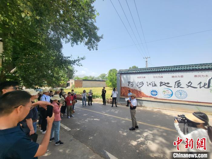 圖為中國地質(zhì)大學(xué)(北京)教授張緒教介紹村落情況?！『衍?攝