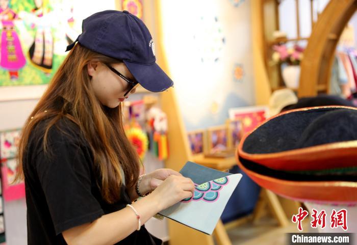 圖為民眾體驗國家級非遺項目盤繡技藝?！⊙Φ?攝