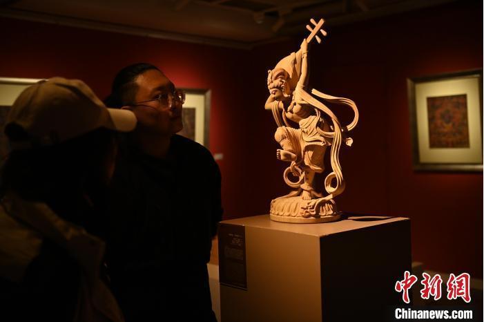 圖為季茂杰向參觀者介紹自己創(chuàng)作敦煌木雕的過程。李亞龍 攝</p>
<p>