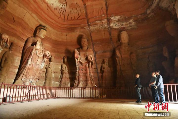 7月15日，游人參觀甘肅省平?jīng)鍪袥艽h百里石窟長(zhǎng)廊中的南石窟寺1號(hào)窟。百里石窟長(zhǎng)廊位于涇川縣境內(nèi)，由512個(gè)石窟、5眼窟中石井組成，現(xiàn)存王母宮石窟、鳳凰山石窟、南石窟寺、丈八寺石窟、羅漢洞石窟、太山寺石窟等規(guī)模較大的石窟群，還有數(shù)量眾多的小石窟群。南石窟寺開鑿于北魏永平三年，其中1號(hào)窟屬于大型七佛窟，七佛高達(dá)6米。中新社記者 李亞龍 攝